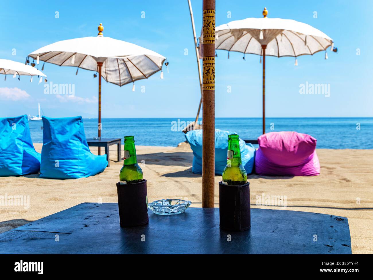 Tisch mit zwei Flaschen Bier, Bali, Indonesien, Südostasien. Tisch mit zwei Flaschen Bier und Blick auf das Meer, Bali, Indonesien. Stockfoto