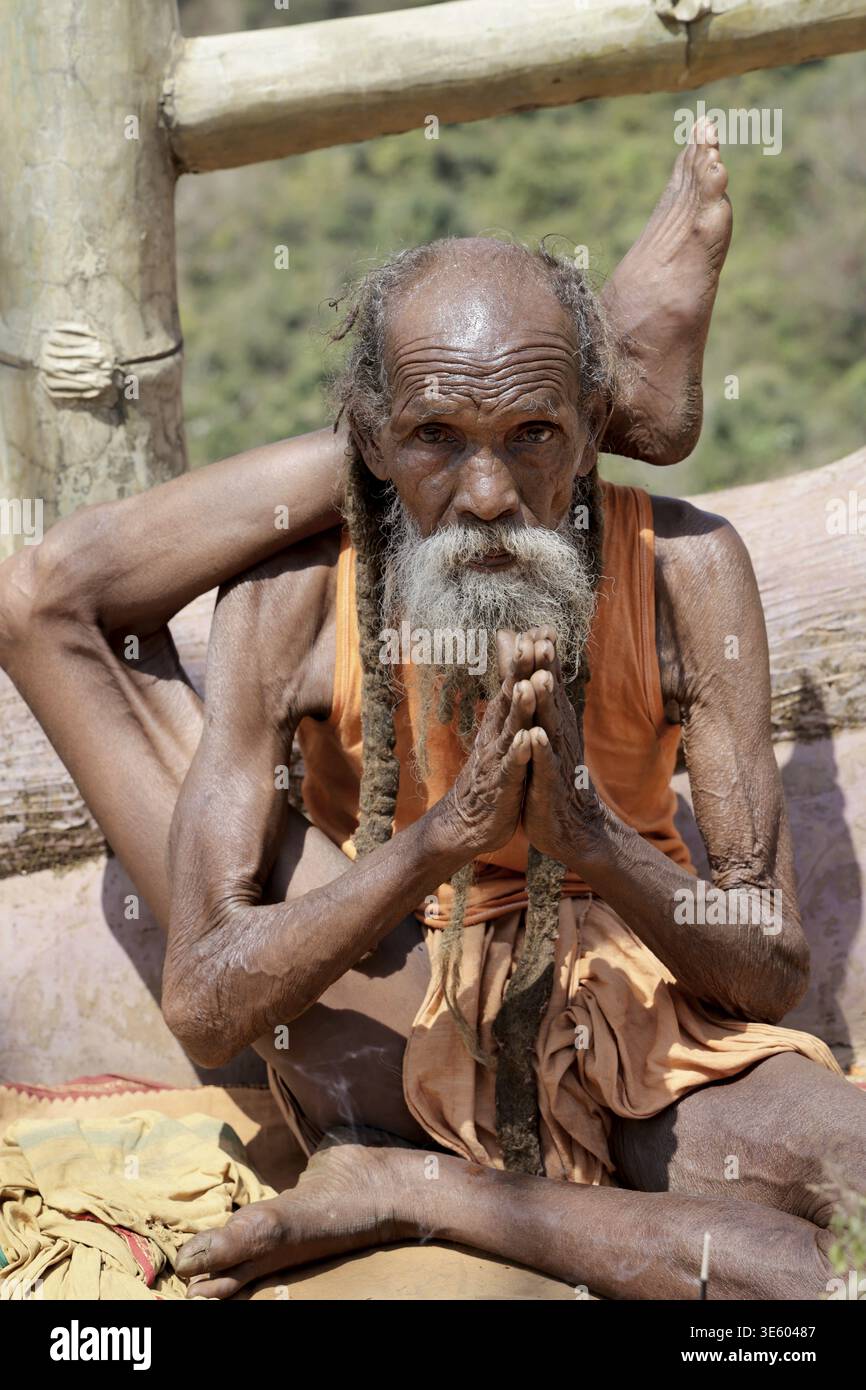 Odisha, Indien - 26. März 2026: Blick auf einen alten Asketen mit verwitterter Haut, verdrehten Gliedmaßen und einem langen Bart, der mit gefesselten Händen sitzt und resil verkörpert Stockfoto