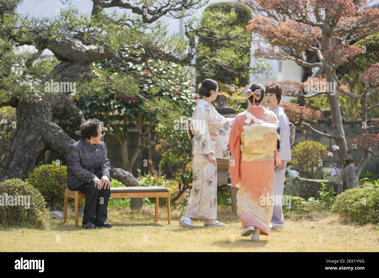 Eine Gruppe von Menschen in traditioneller japanischer Kleidung steht in einem Park Stockfoto