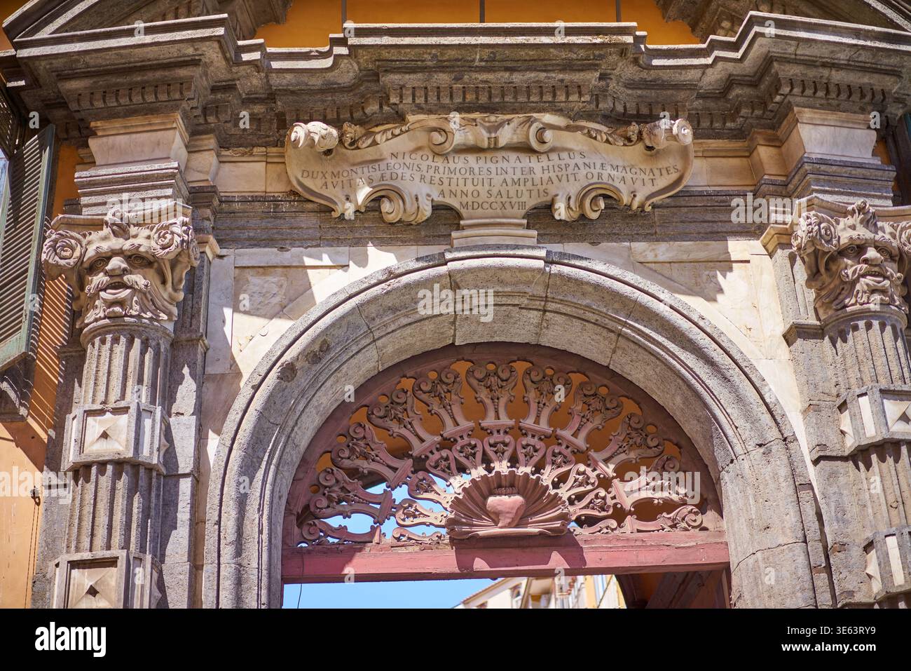Nahaufnahme eines kunstvollen barocken Steinportals in einem historischen italienischen Gebäude mit einem großen Rundbogen mit rustikalem Steinrahmen Stockfoto