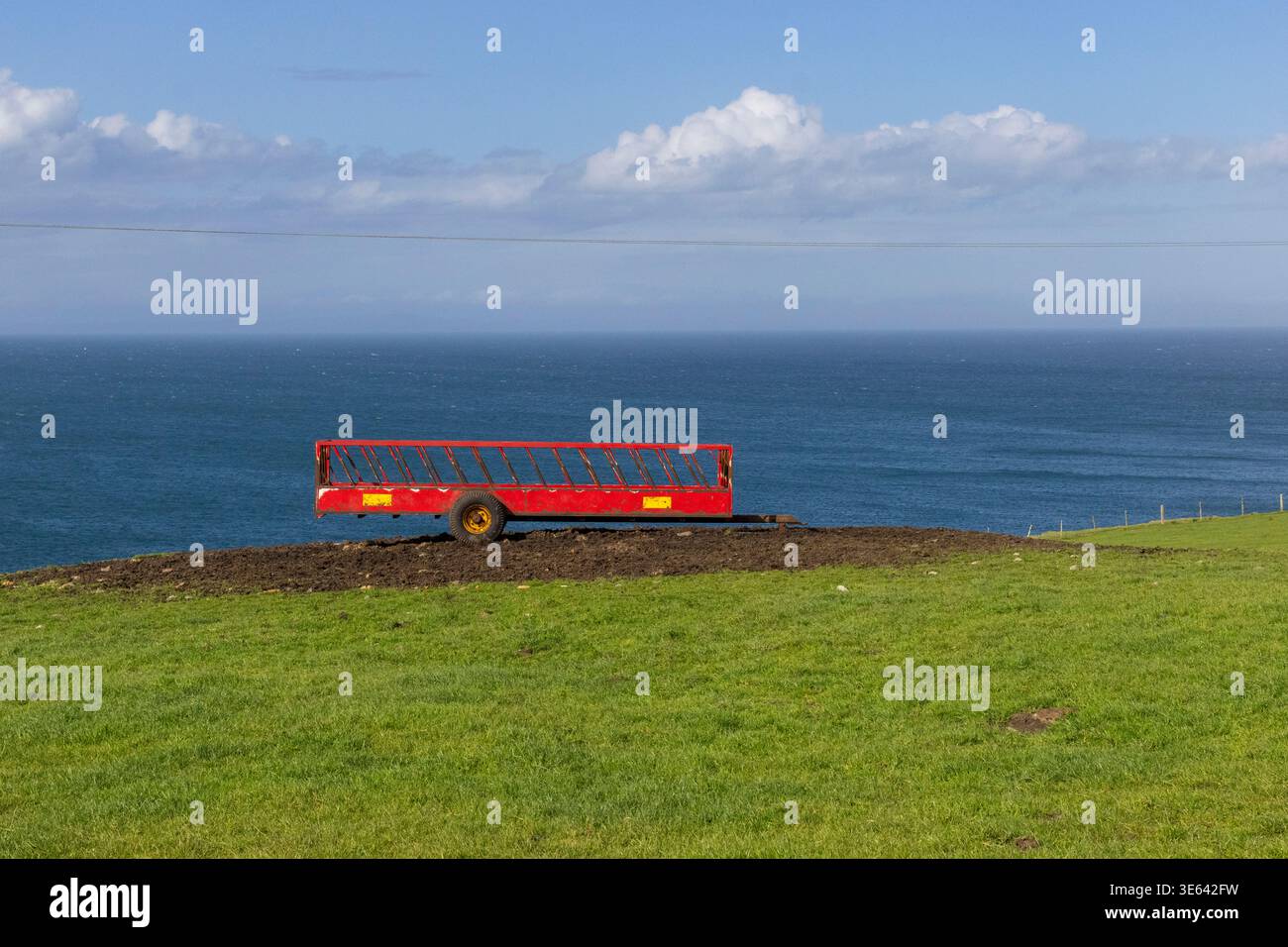 Grünes Gras, roter Landanhänger und irische See aus der Mull of Galloway, Schottland, Großbritannien Stockfoto