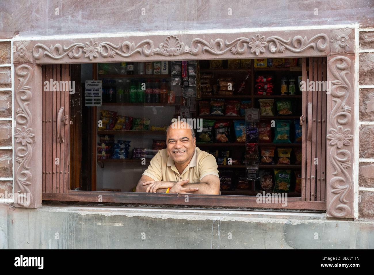 Ein männlicher Ladenbesitzer sitzt hinter dem Tresen in seinem Geschäft in Jodhpur, Indien Stockfoto