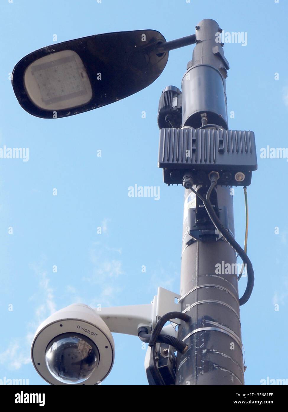 Blick auf die Straßenlaterne im Stadtzentrum und die Überwachungskamera, die an einem Lampenpfosten montiert ist, vor einem hellblauen Himmel, in Bath, Somerset, Großbritannien Stockfoto