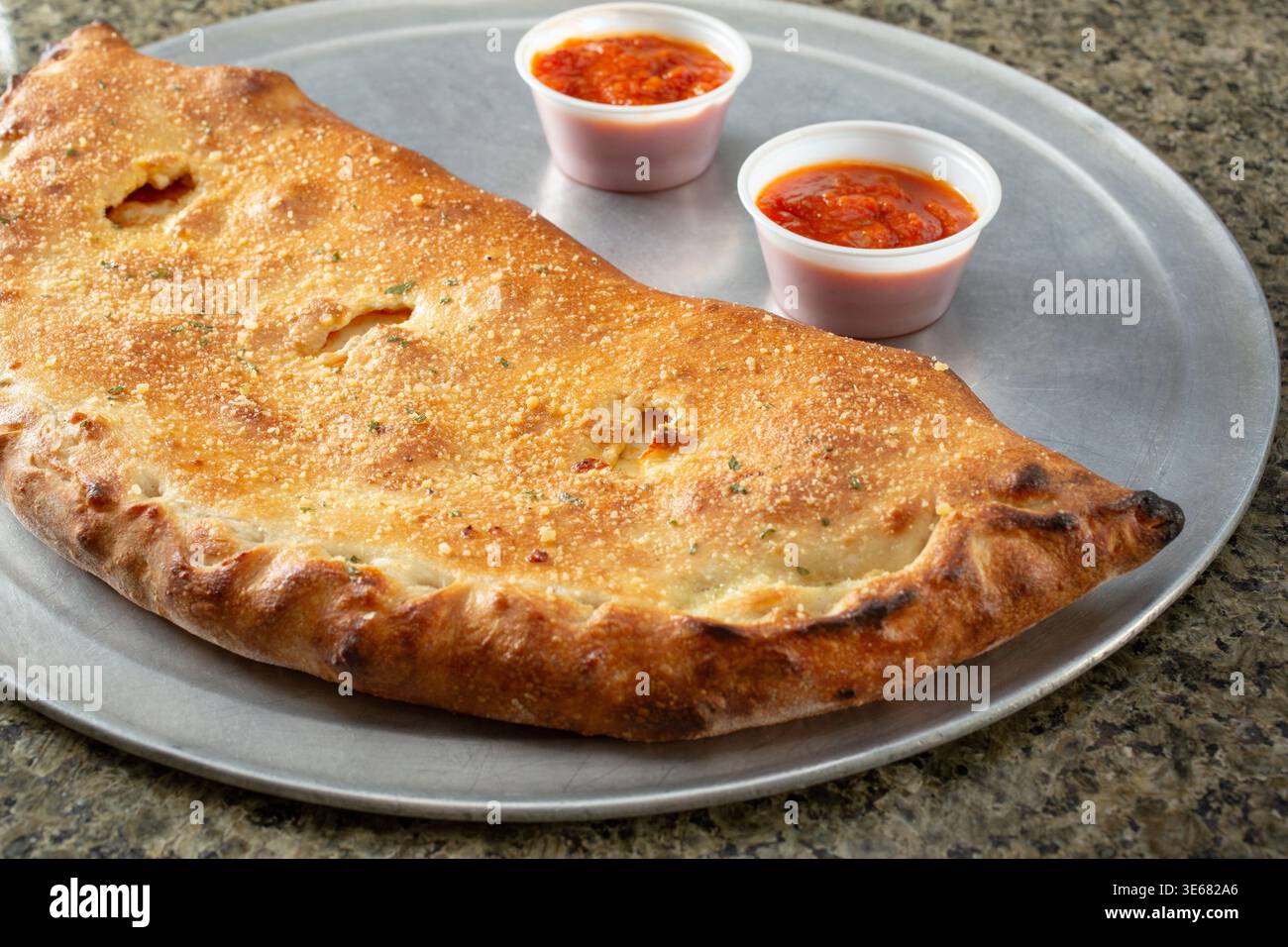 Blick auf eine Calzone auf einer Pizzaform. Stockfoto