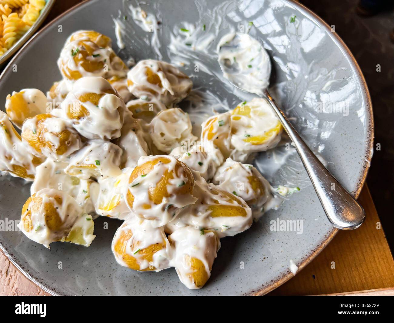Kartoffelsalat wird als Teil eines Mittagsbuffets serviert - Smartphone-aufgenommenes Stockfoto