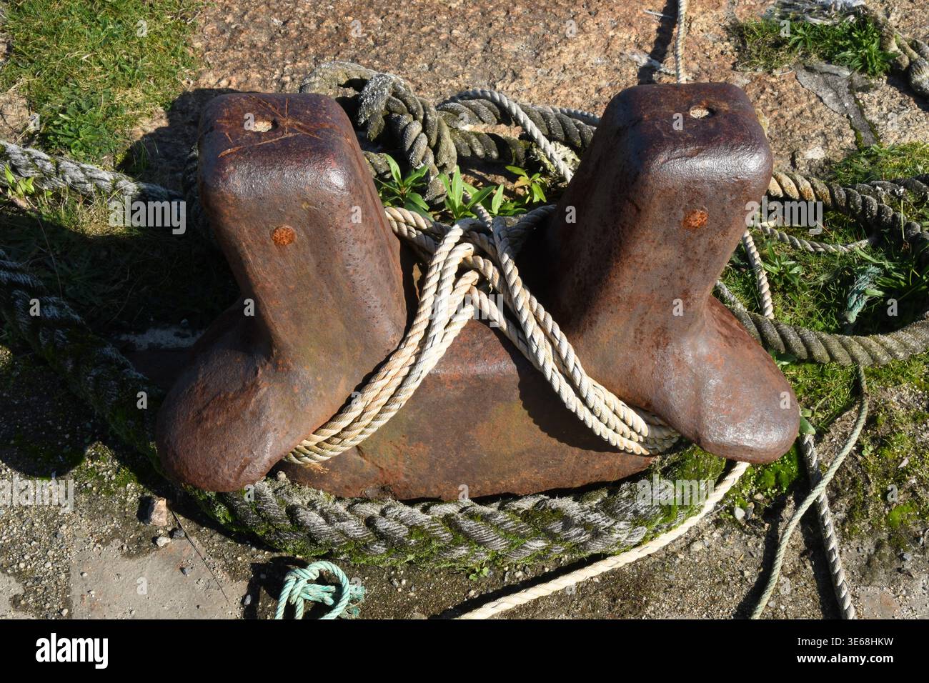 Gusseiserner Schiffspoller mit alten Seilen an einem alten Granitkai in der Nähe von Hayle in Cornwall Stockfoto