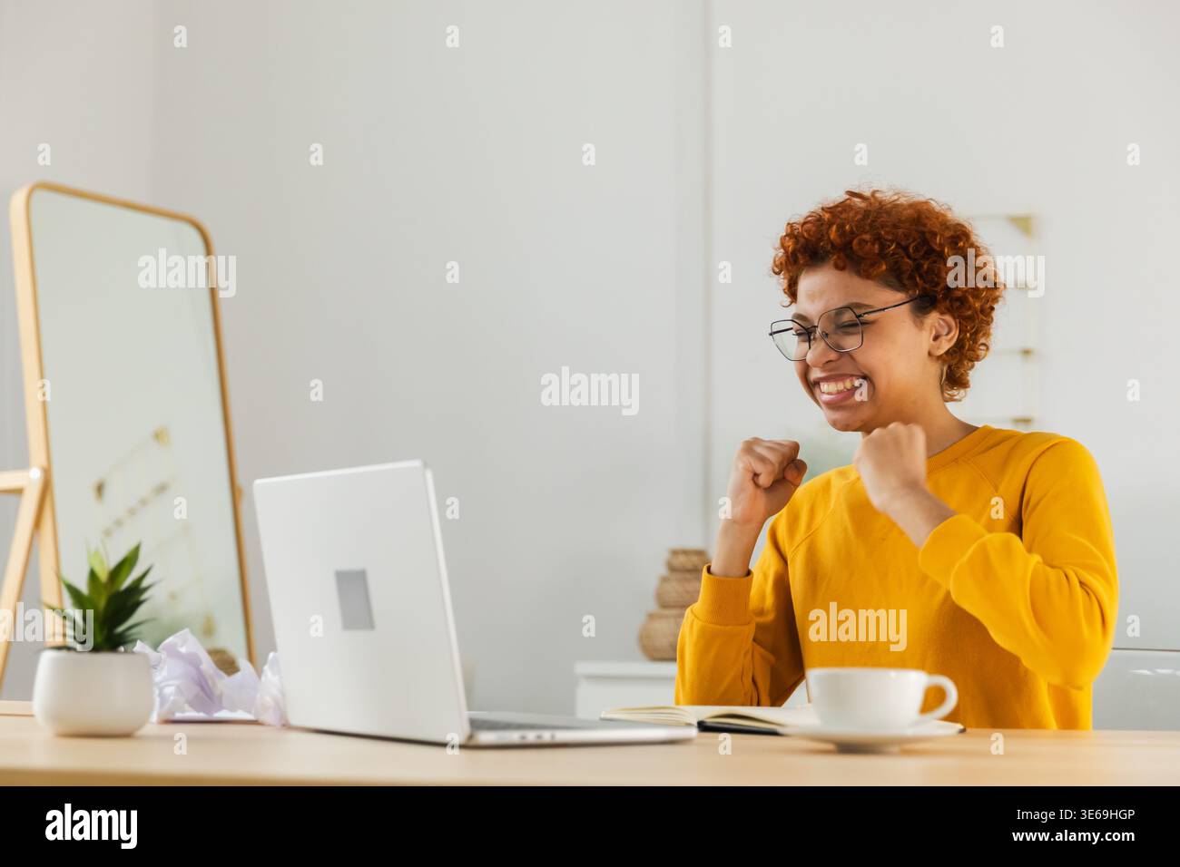 Aufgeregt glückliche afroamerikanische Frau euphorische Siegerin. Mädchen, die auf einen Laptop schaut, hat die Prüfung bestanden und tolle Nachrichten gelesen und gute Ergebnisse erzielt Online-Angebote gewonnen und sich zu Hause staunend gefühlt. Siegergeste Stockfoto