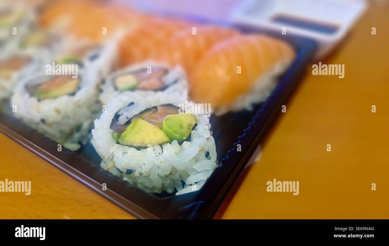 Sushi und Nigiri auf einer Plastikplatte zum Mitnehmen, fertig zum Verzehr Stockfoto