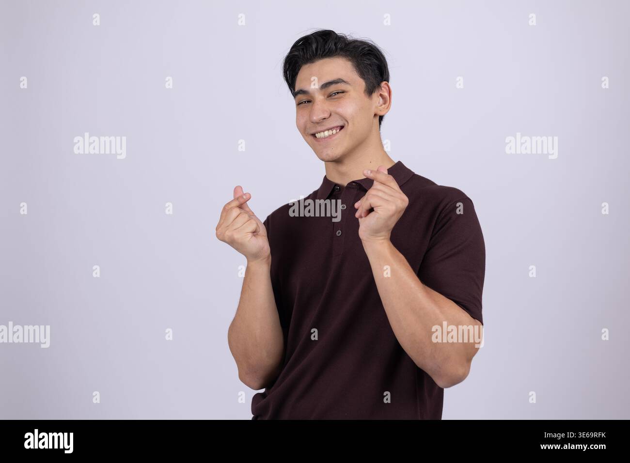 Ein Mann, der mit seinen Fingern eine Herzgeste macht Stockfoto