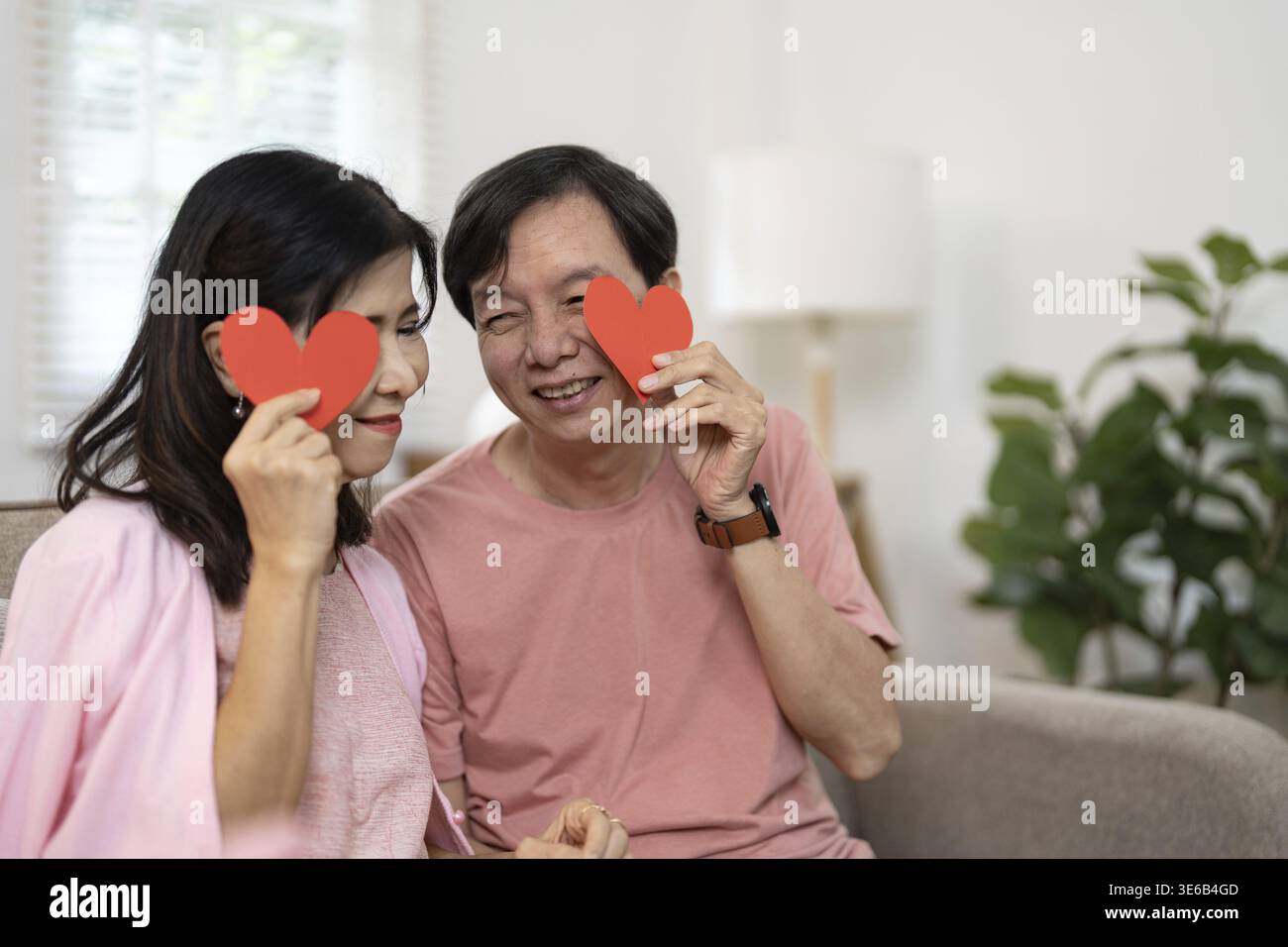 Älteres Ehepaar, das einen liebevollen Moment genießt, symbolisiert dauerhafte Romantik und Gesellschaft in einer warmen, einladenden Atmosphäre Stockfoto