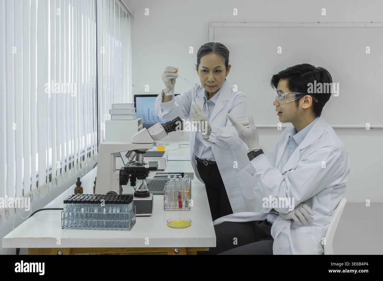Wissenschaftler mit einem Reagenzglas, das Cannabisextrakt enthält Stockfoto