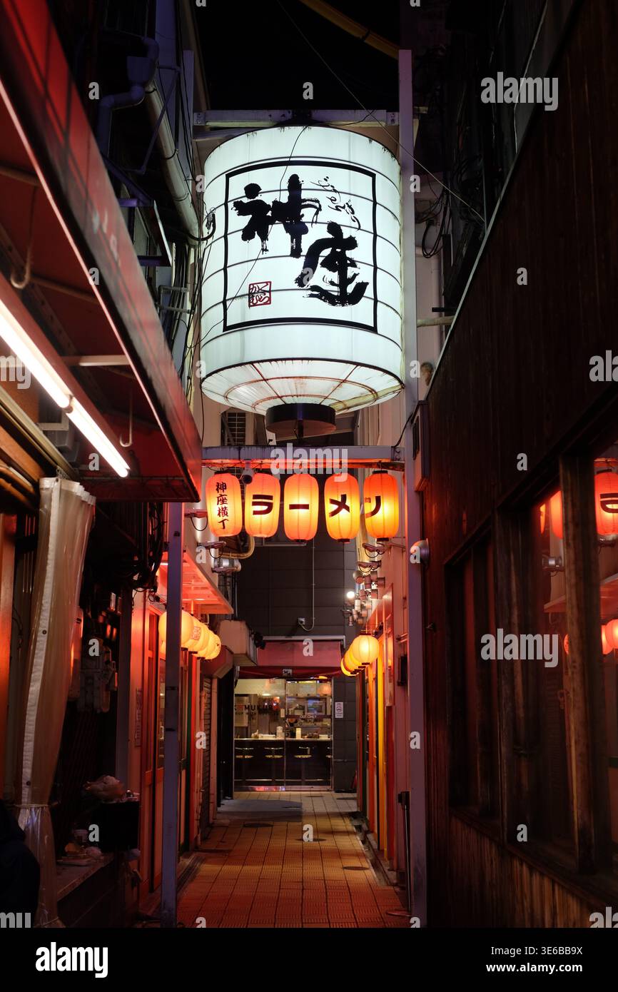 Traditionelle japanische Papierlaternen, die nachts in einer engen Gasse leuchten, die zu einem Ramen-Restaurant in japan führt Stockfoto