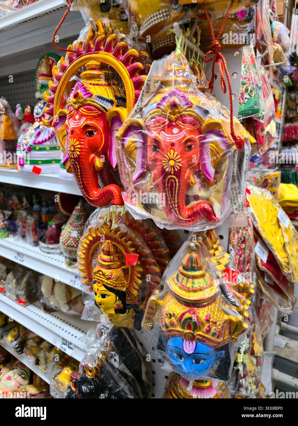 Farbenfrohe handgefertigte Figuren von Lord Ganesha, Hantuman und traditionellen indischen Charakteren in einem Ladenregal, die lebendige Kultur zeigen - Smartphone-aufgenommenes Stockfoto