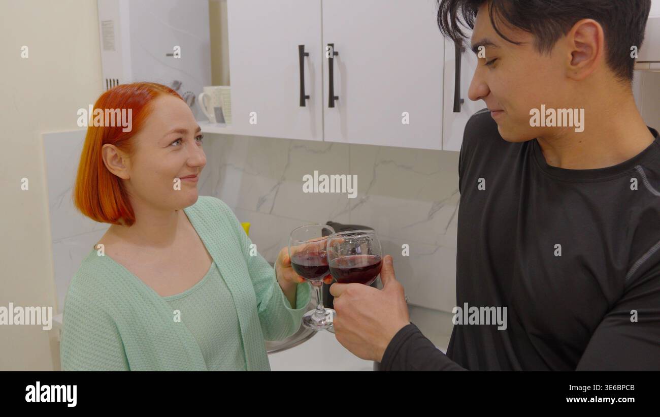 Mann und Frau unterhalten sich mit Brille in der Küche Stockfoto