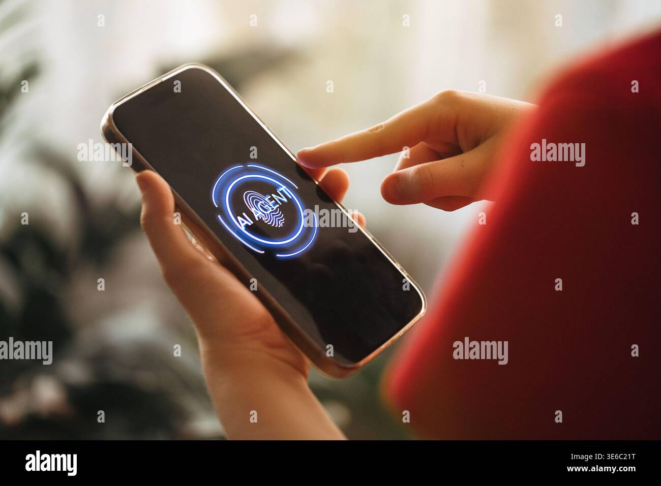 Individual interagiert mit dem Smartphone mit KI-Schnittstelle auf dem Bildschirm, berührendem Display, verschwommenen Innenpflanzen und sanfter Beleuchtung auf der Rückseite Stockfoto