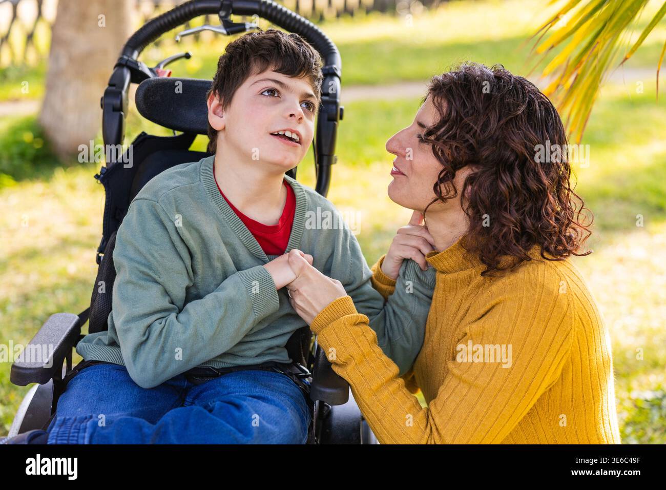 Mutter mit behindertem Sohn im Rollstuhl im Parkhaus Stockfoto