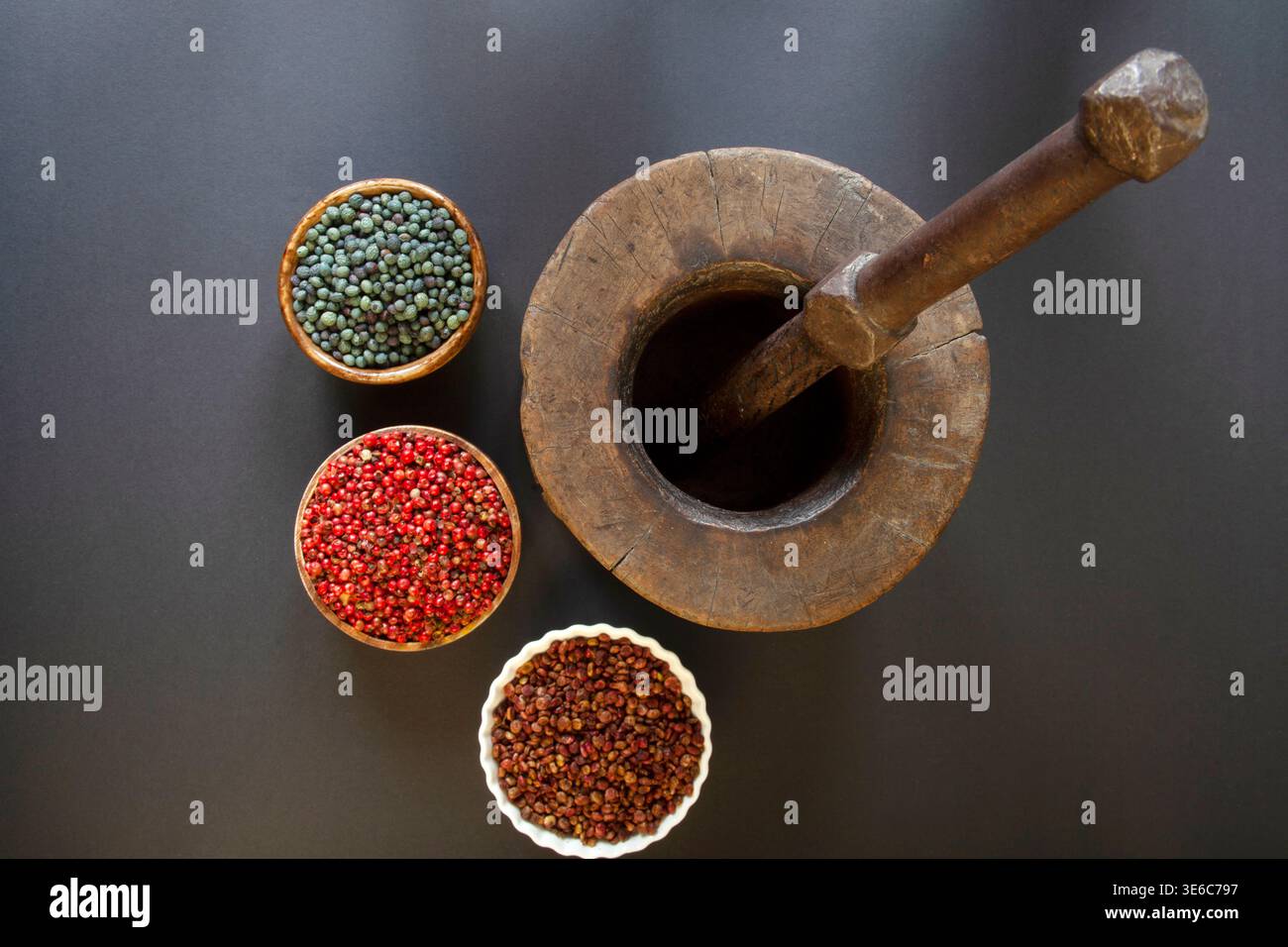 Samen, die zum Mahlen im Mörtel vorbereitet werden. (Pistacia terebinthus) Rote Pfefferkerne und Sumakkerne. Stockfoto