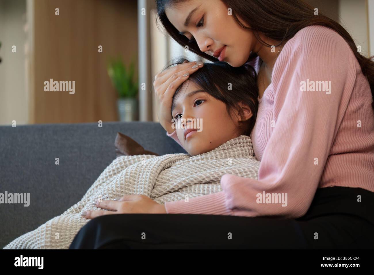 Mutter kümmert sich um ihr krankes Kind zu Hause Stockfoto