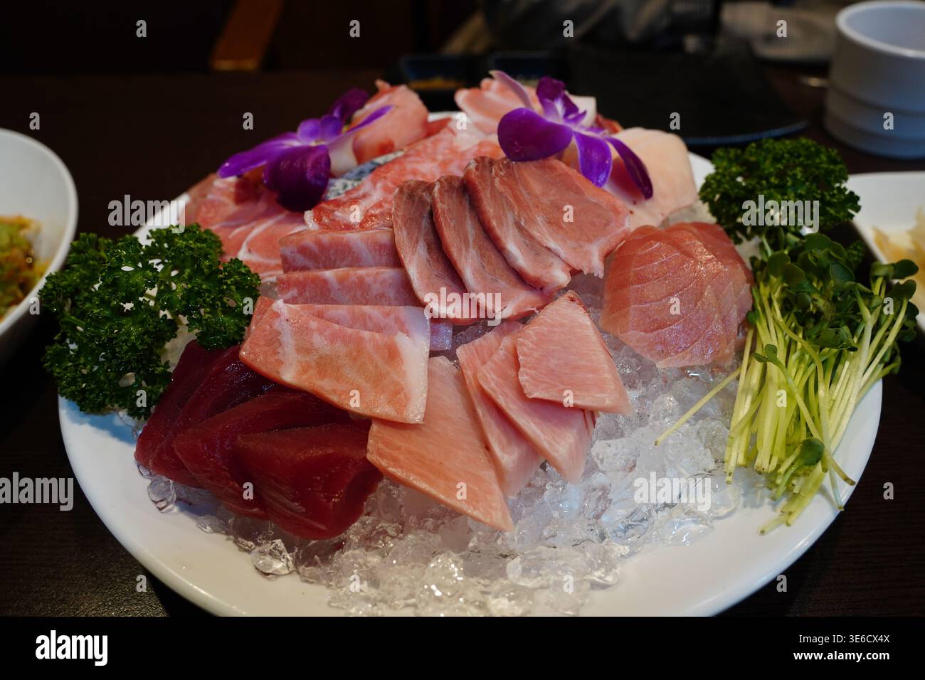 Frische Premium Thunfisch-Sashimi-Platte serviert auf zerstoßenem Eis mit Garnitur Stockfoto