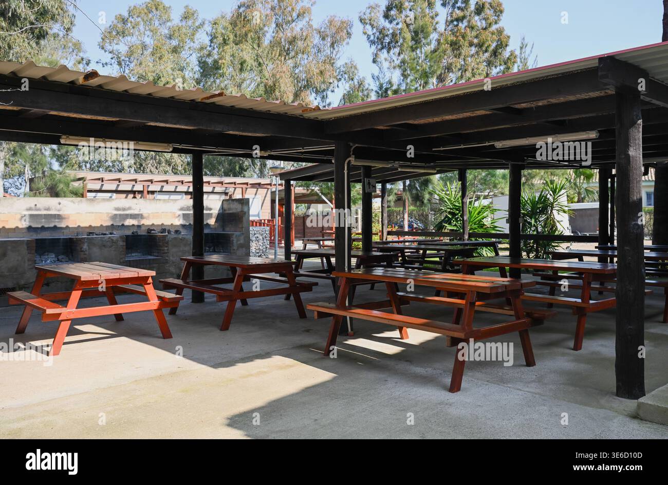 Hölzerne Picknicktische unter überdachtem Unterschlupf im Campingplatz Park Restaurant im Freien Reise- und Freizeitkonzept Stockfoto