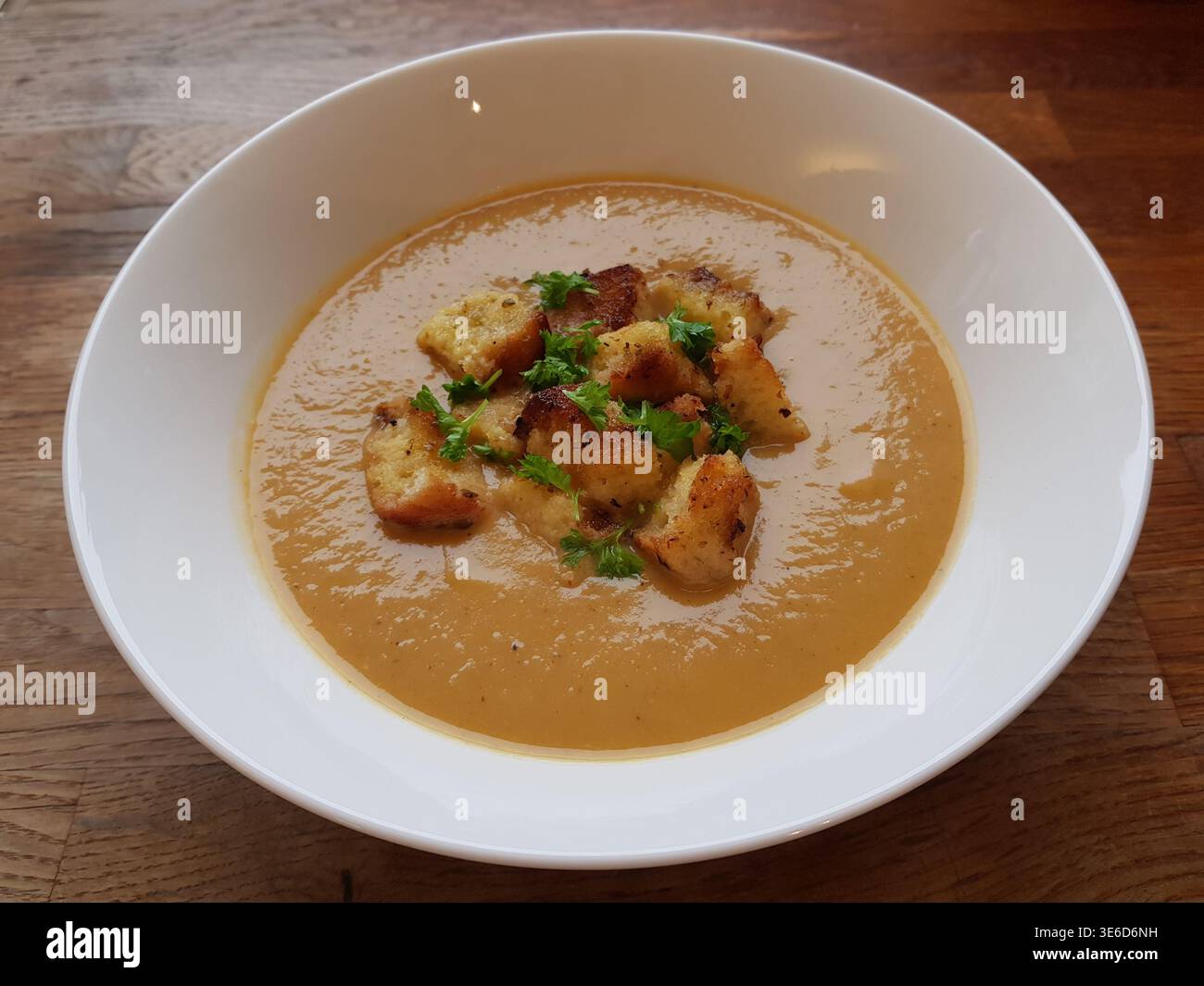 Karotten- und Linsensuppe. Serviert mit Croutons und Petersilie Stockfoto
