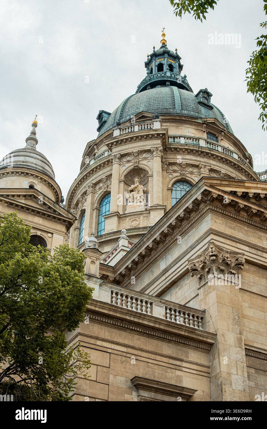 Imposante Budapester Kathedrale Mit Aufwändiger Neoklassischer Architektur, Umgeben Von Bäumen Und Skulpturen Stockfoto