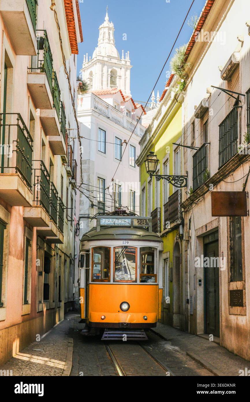 Gelbe Straßenbahn in Alfama am sonnigen Tag. Lissabon, Portugal Stockfoto