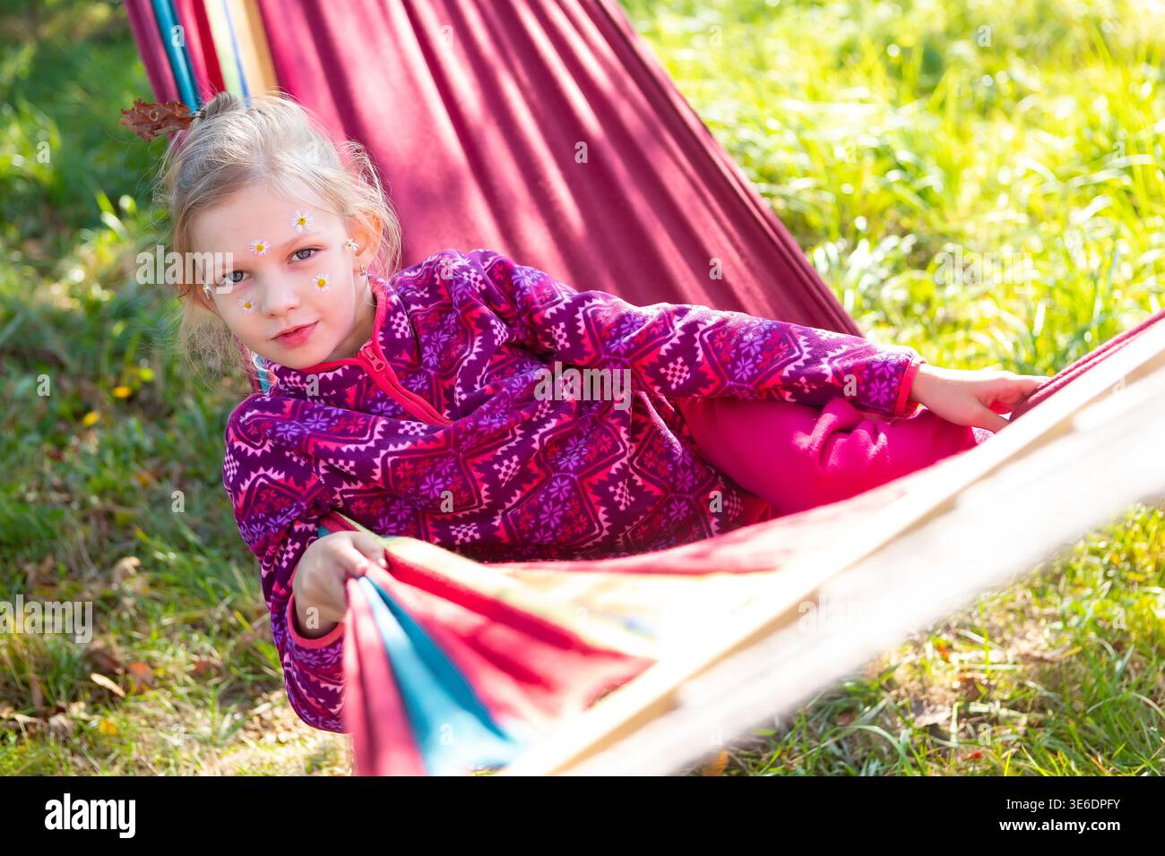 Kind genießt die Zeit in der Hängematte während des Sonnentages im Park Stockfoto