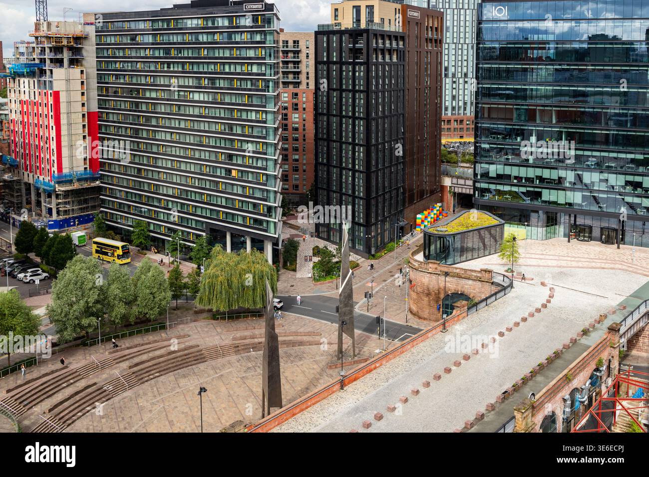 Erhöhter Blick über die Greengate-Gegend von Salford, mit CitySuites-Apartmenttürmen und gelbem Bus, im Sommer. Stockfoto
