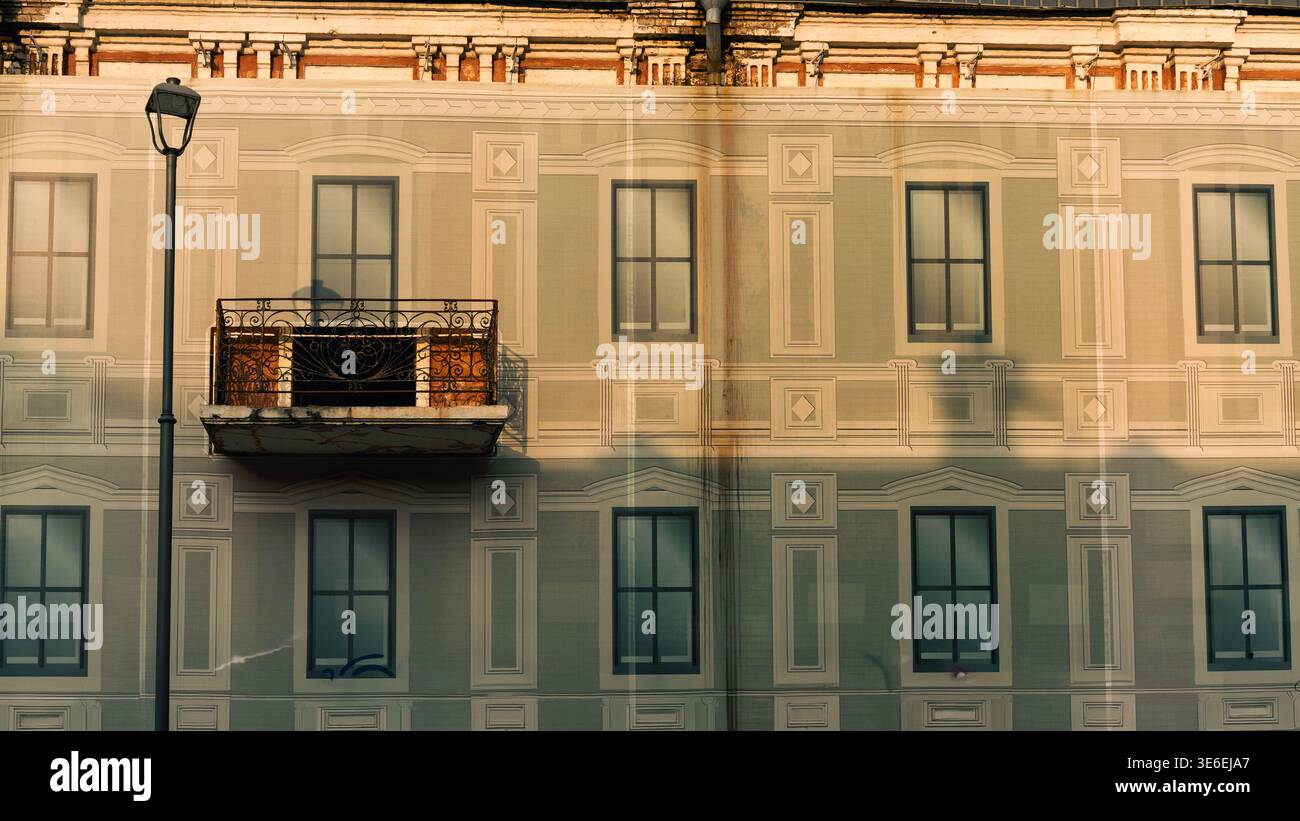Architektonische Details einer historischen Gebäudefassade, die teilweise mit einer bedruckten dekorativen Oberfläche bedeckt ist, schaffen eine Illusion von Fenstern und Klassik Stockfoto