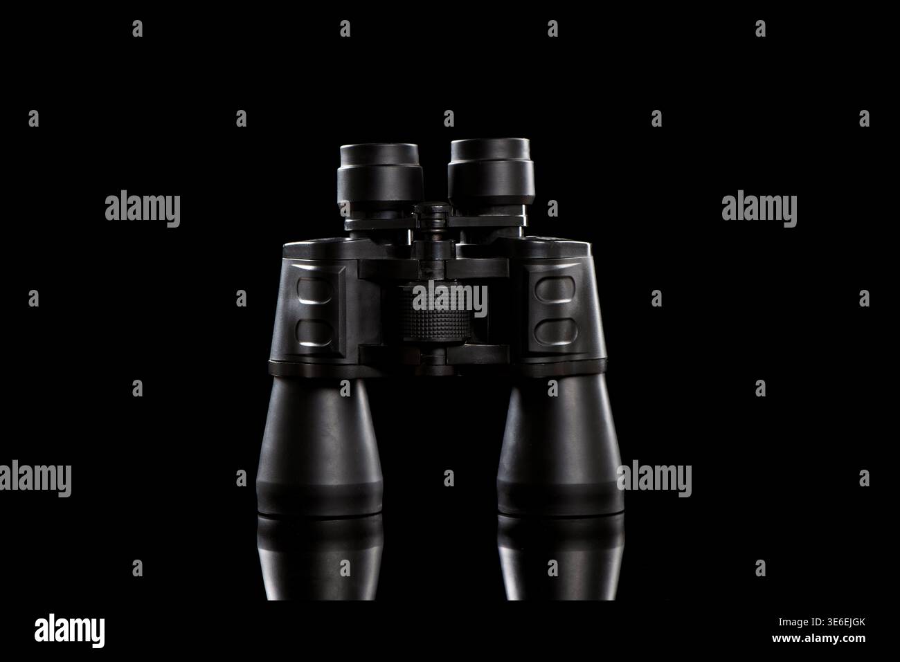 Schwarzes Fernglas mit präzisen Details des optischen Instruments auf einer dunklen, reflektierenden Oberfläche Stockfoto