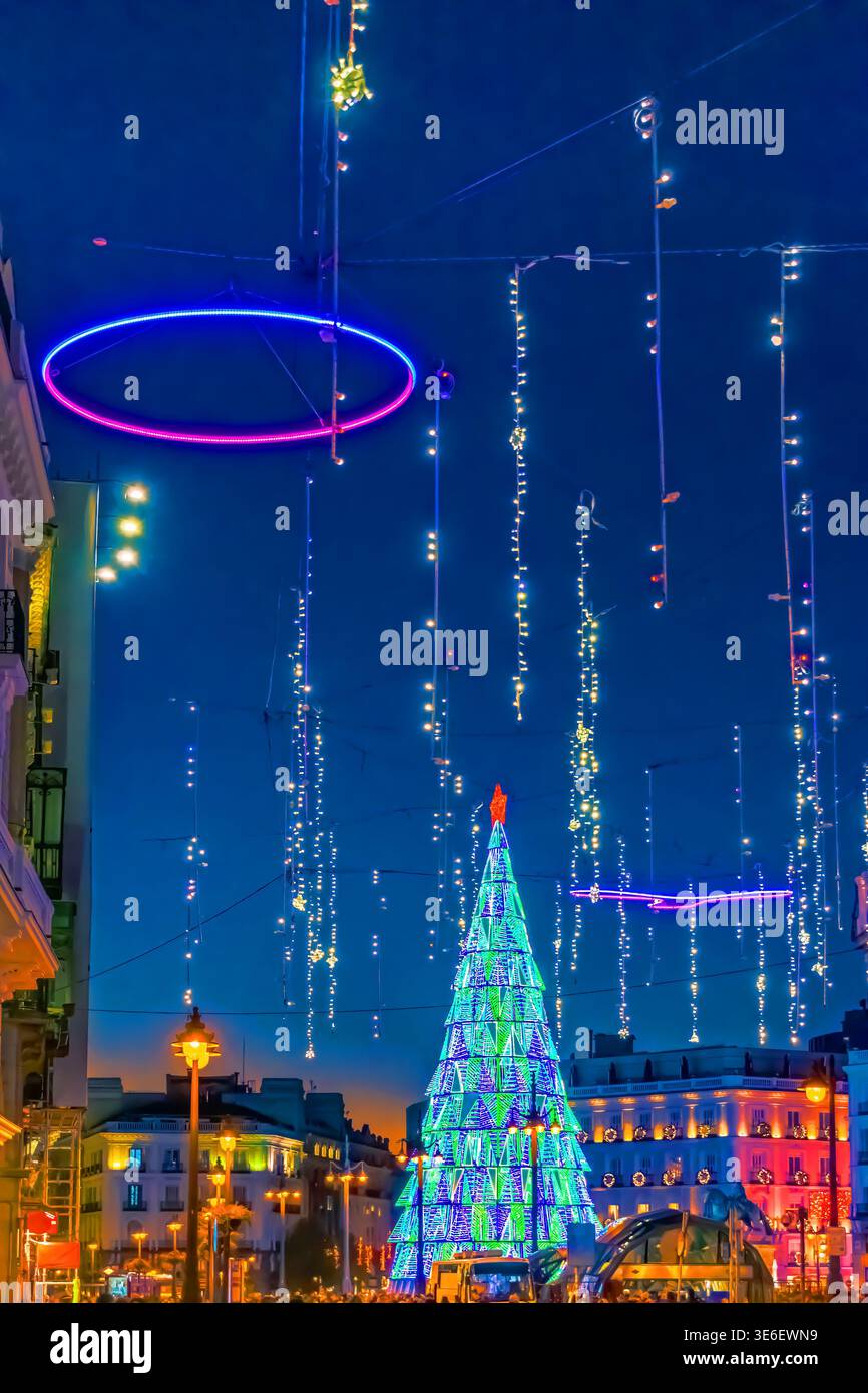 Farbenfrohe Weihnachtslichter und -Dekorationen erleuchten die Straßen von Madrid, Spanien, im Jahr 2021, mit einem hoch aufragenden Weihnachtsbaum, der in Blau und Grün leuchtet Stockfoto