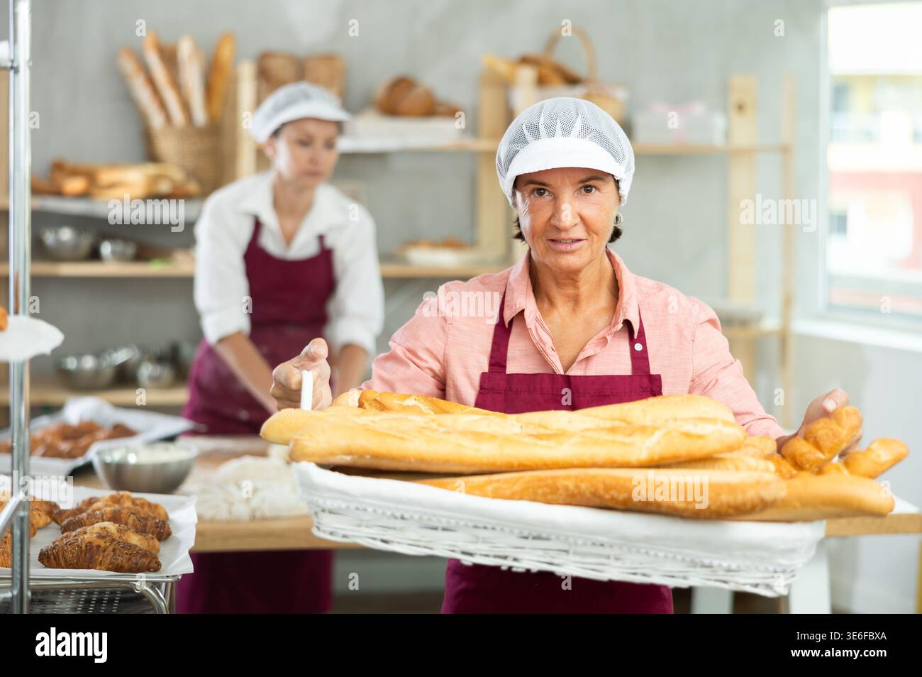 Porträt der fröhlichen älteren Bäckerin Stockfoto