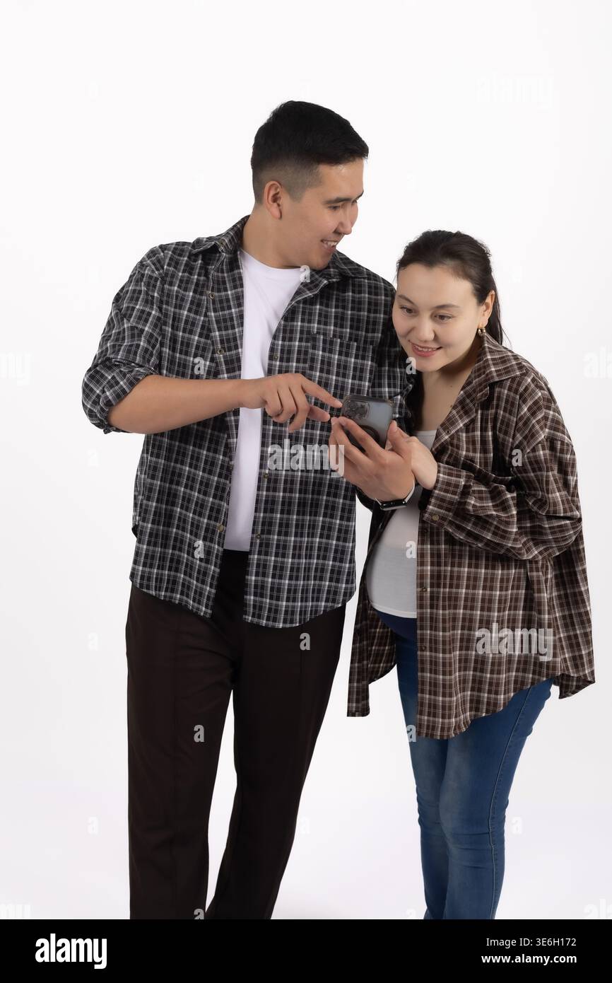 Mann und Frau, die gemeinsam im Studio auf das Smartphone schauen Stockfoto
