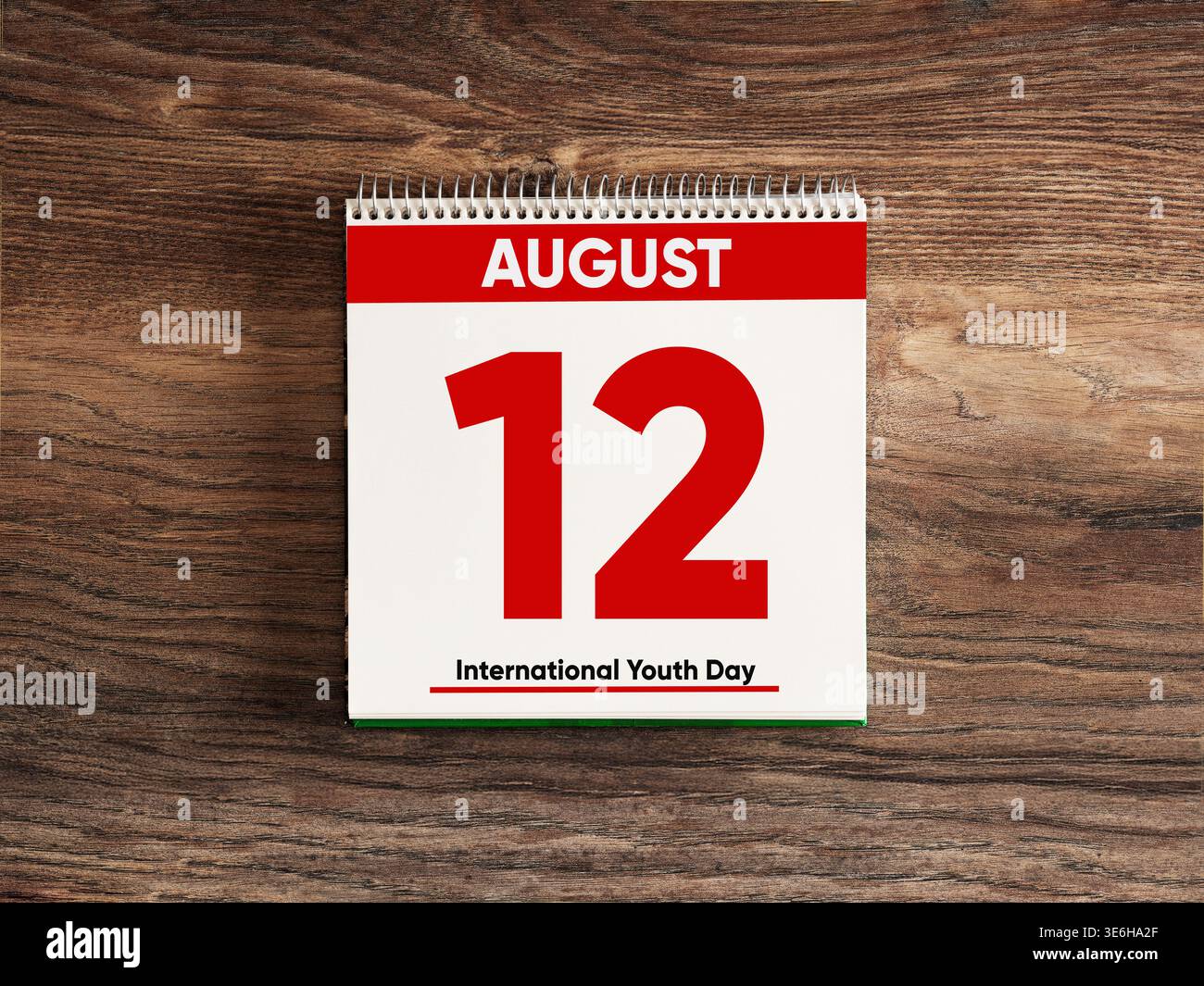 Weißer Schreibtischkalender mit dem 12. august für den internationalen Jugendtag auf einem dunklen Holztisch Stockfoto