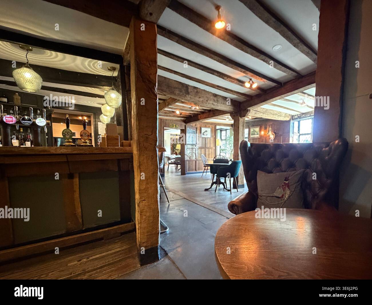 Gemütliche Bar im Tudor-Stil im Hotel Indigo Stratford-upon-Avon mit Eichenbalken, warmer Beleuchtung und traditionellem Boutique-Hotel-Design. Stockfoto