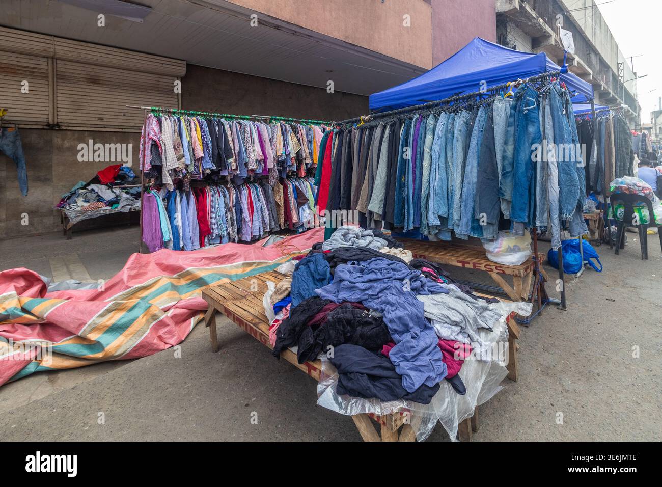 Einkaufen von gebrauchten Kleidern an einem Straßenstand in Cebu City, Philippinen, Teil eines Wochenend-Sonntagsmarktes, der Secondhand-Jeans und Bekleidung verkauft Stockfoto