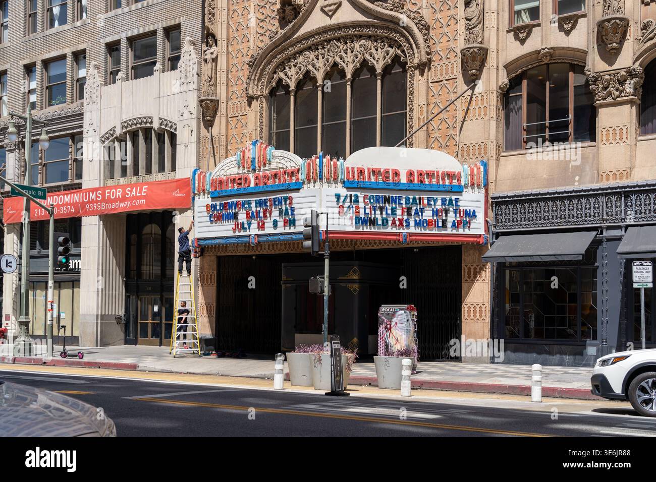 Zwei Arbeiter, die ihre Briefwechsel an der Fassade des United Artists Theatre in der Innenstadt von Los Angeles am 937 South Broadway, Los Angeles, KALIFORNIEN, USA ändern Stockfoto