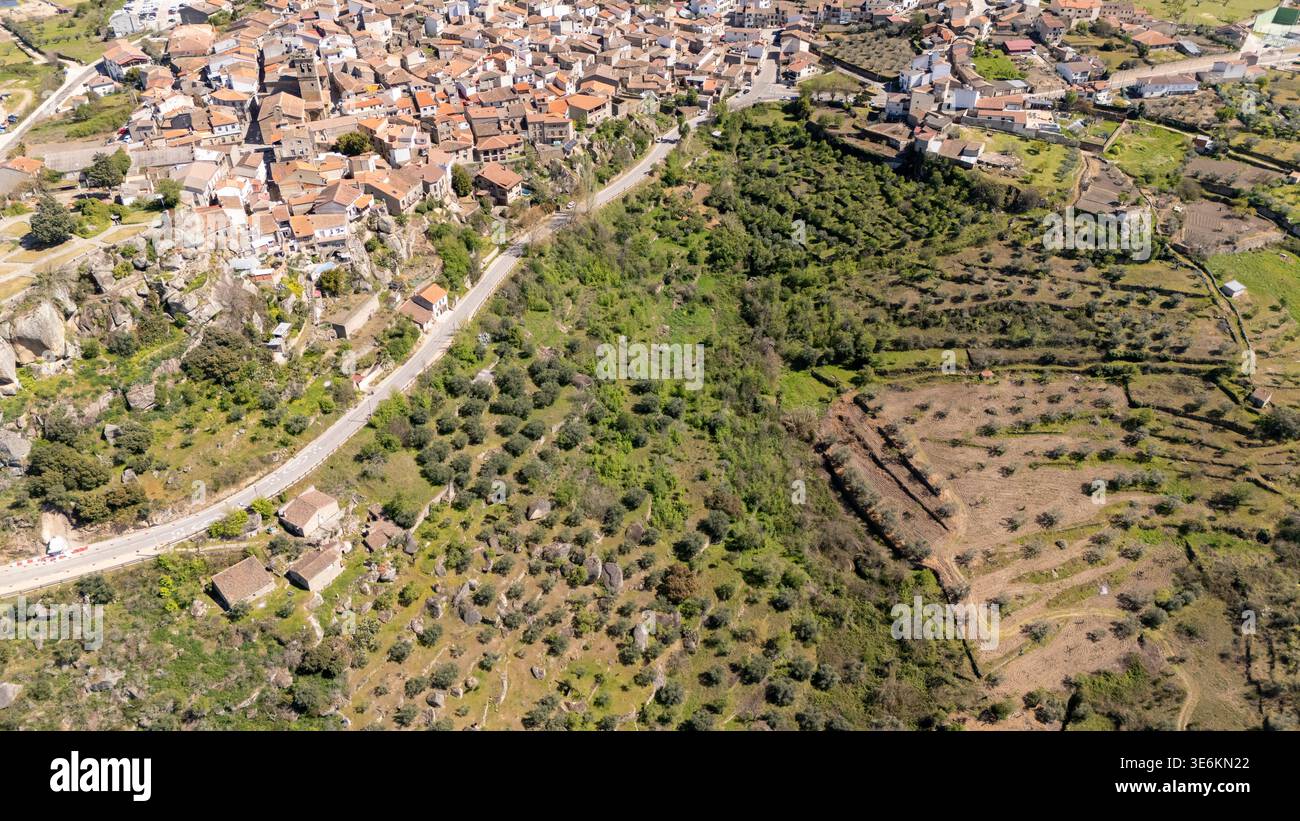 Aus der Vogelperspektive zeigt die historische spanische Stadt, die ländliche Landschaft, die gewundene Straße und die traditionelle Landwirtschaft Stockfoto