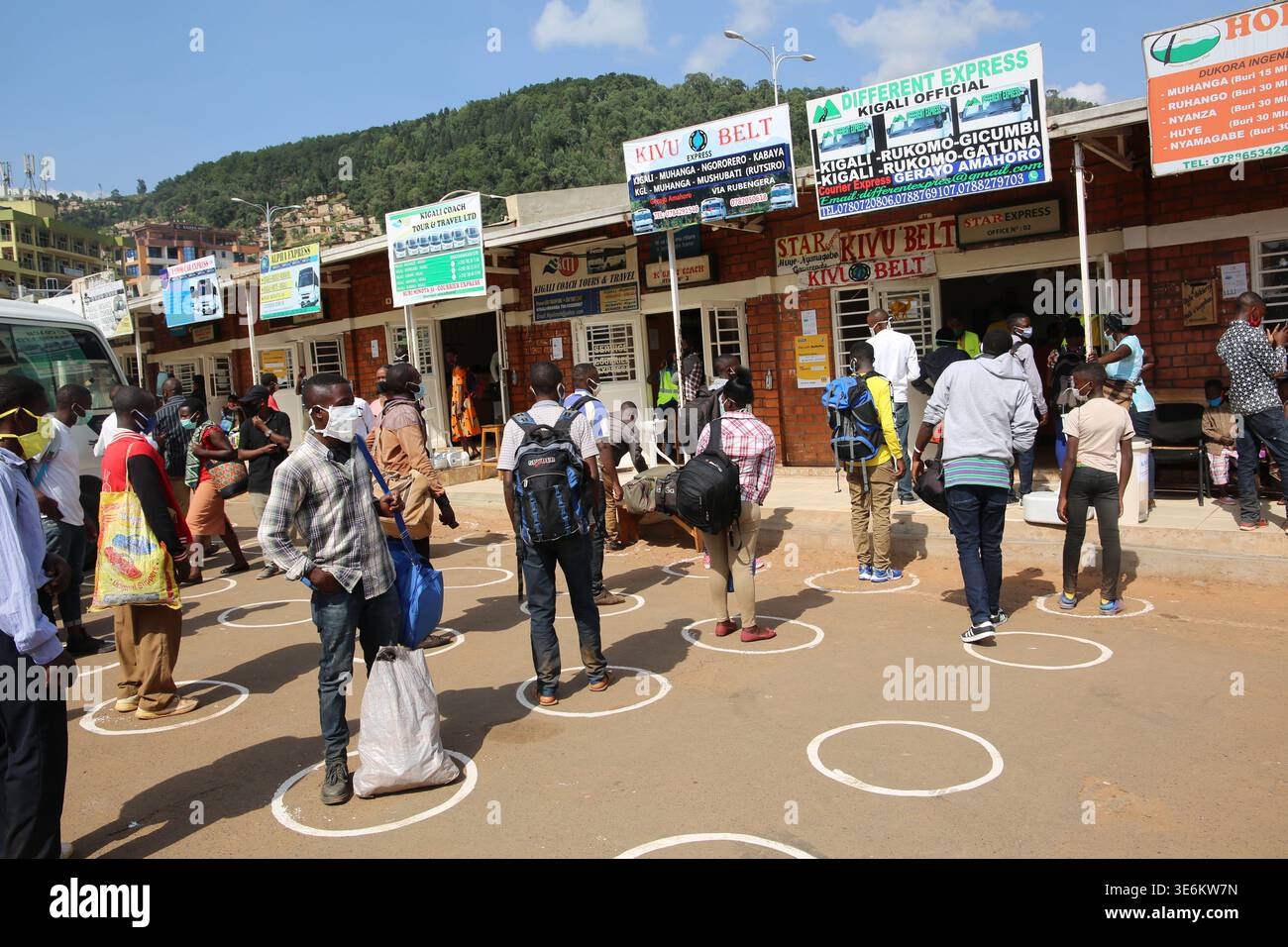 Die Einwohner Kigalias beachten die COVID-19-Richtlinien zur Prävention, einschließlich sozialer Distanzierung, des Tragens von Gesichtsmasken und des Händewaschens vor dem Einsteigen in Busse; Stockfoto