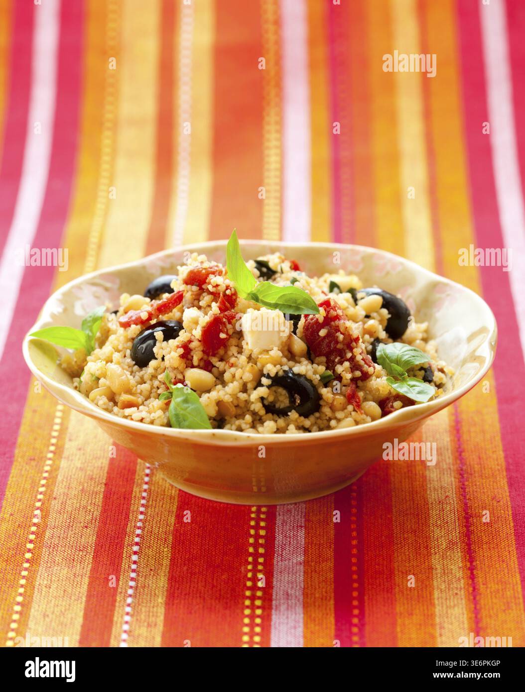 Essen, mediterraner Couscous-Salat mit getrockneten Tomaten, Feta, Oliven und Basilikum Stockfoto