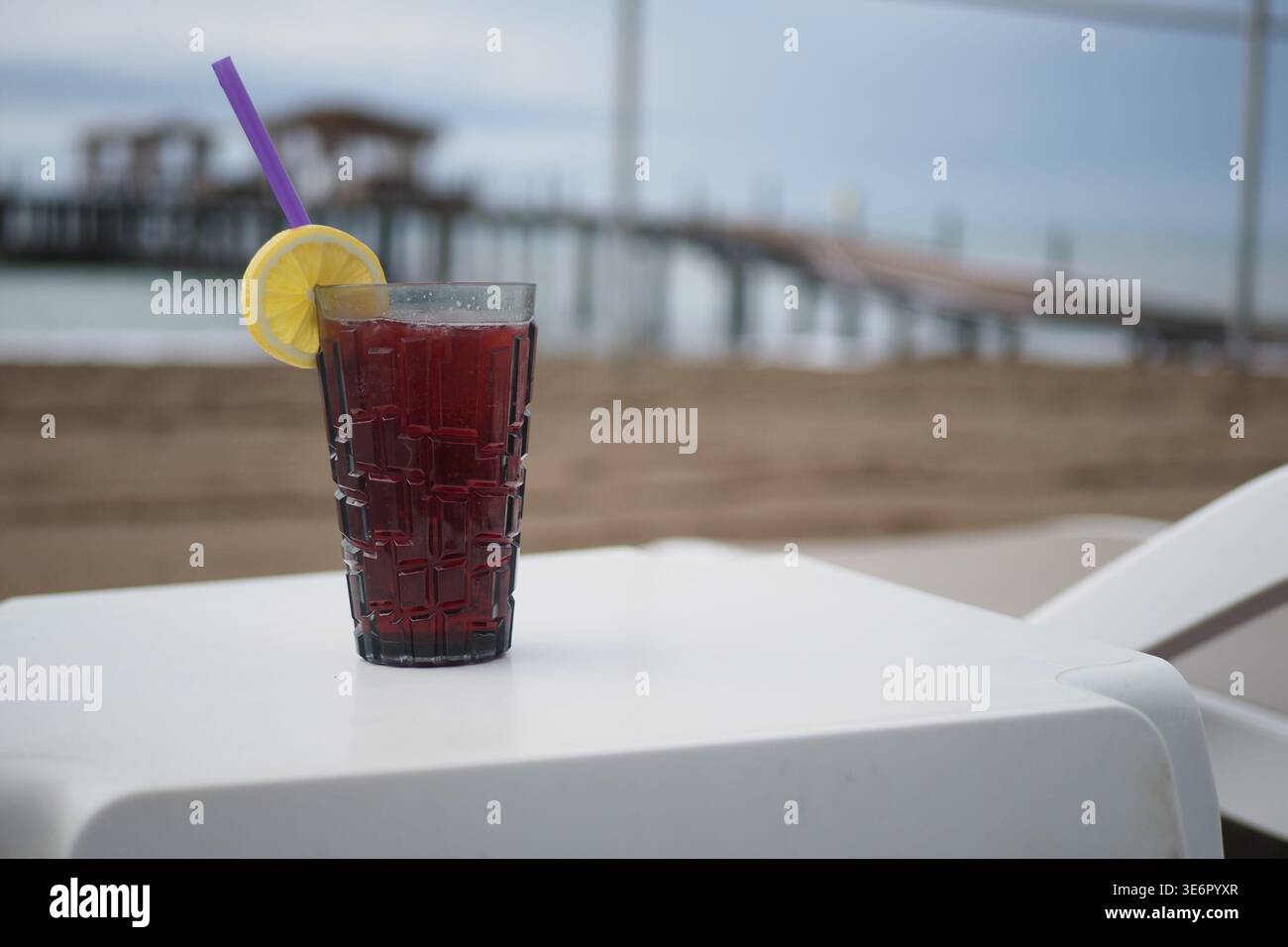 Am frühen Abend steht ein kaltes Getränk auf einem Tisch am Strand Stockfoto