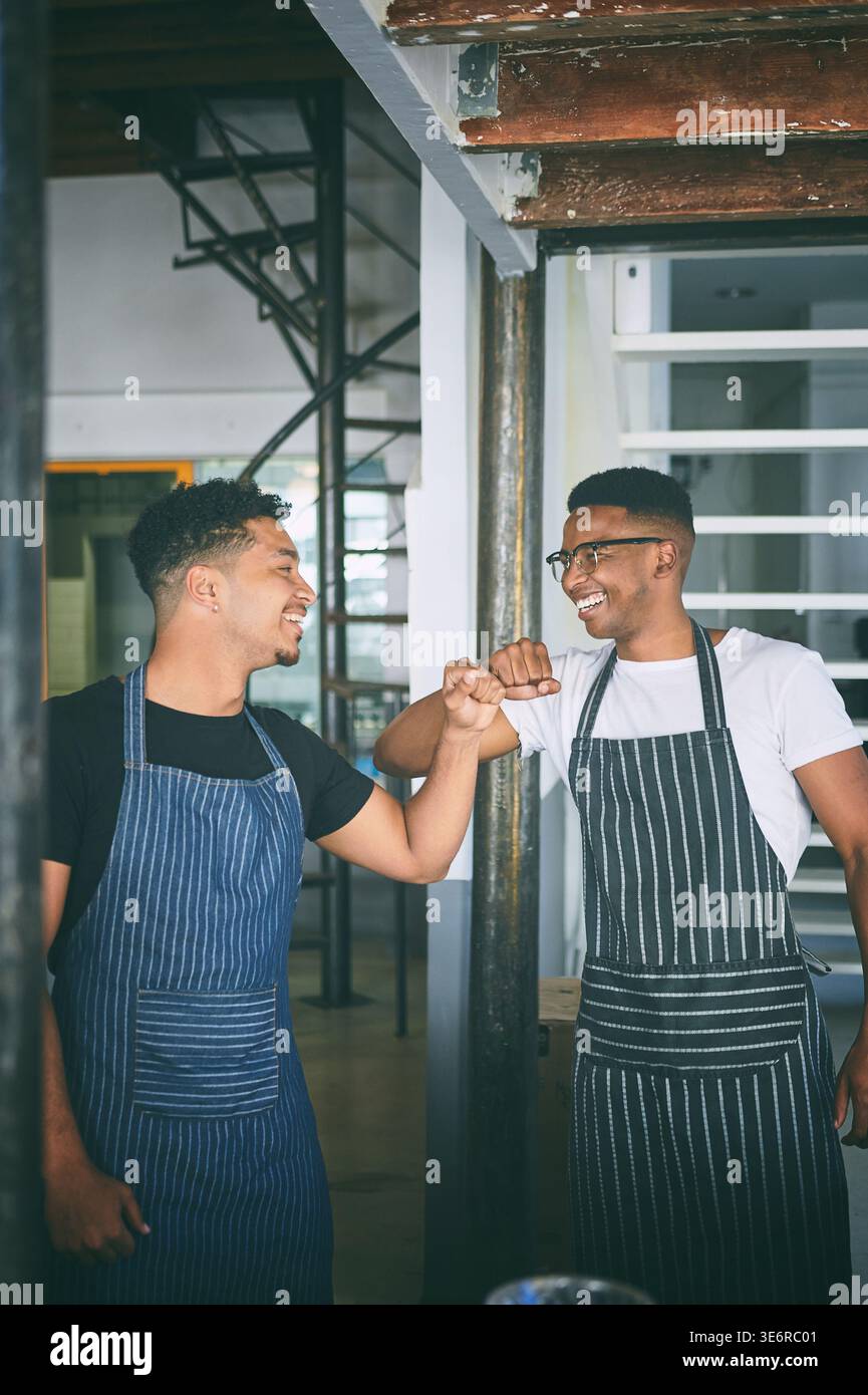 Gastfreundschaft, Happy oder Team im Café mit Faustschlag, Begrüßung oder Partnerschaft Motivation im Bistro. Zusammenarbeit, Männer oder Barista-Mitarbeiter mit Handschlag Stockfoto