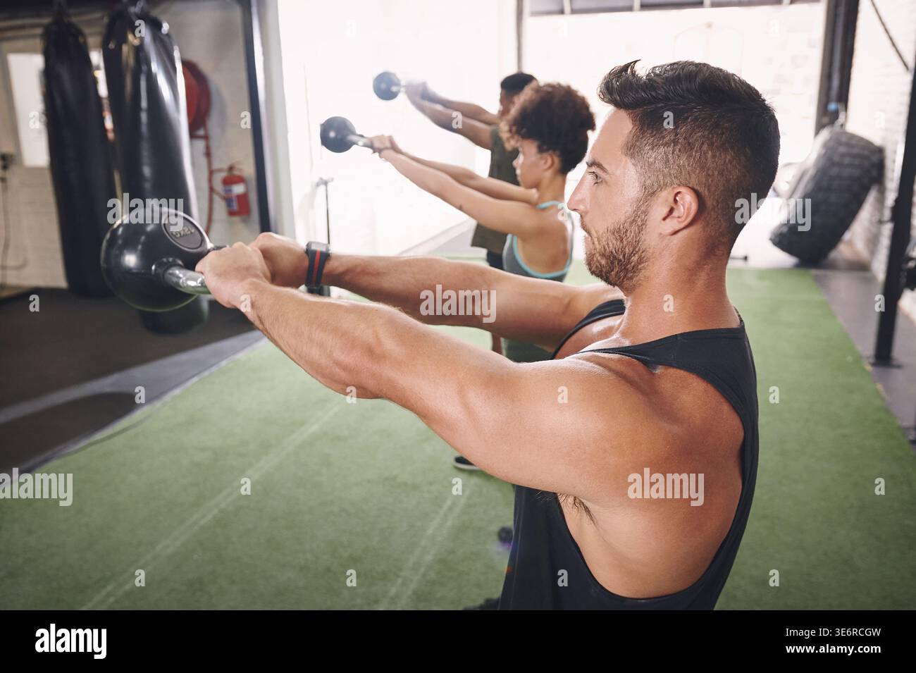 Kettlebells, Bewegung und Menschen im Fitnessstudio, Herausforderung für gesundheitliche Vorteile und Ausdauer. Gruppe, Männer und Frauen in der Einrichtung, Ausrüstung für Workout und Stockfoto
