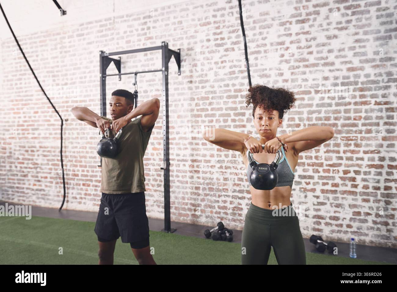 Kettlebells, Workout und Menschen im Fitnessstudio, Fitness für gesundheitliche Vorteile und Herausforderung. Stark, Mann und Frau in der Einrichtung, Ausrüstung für Sport und Stockfoto
