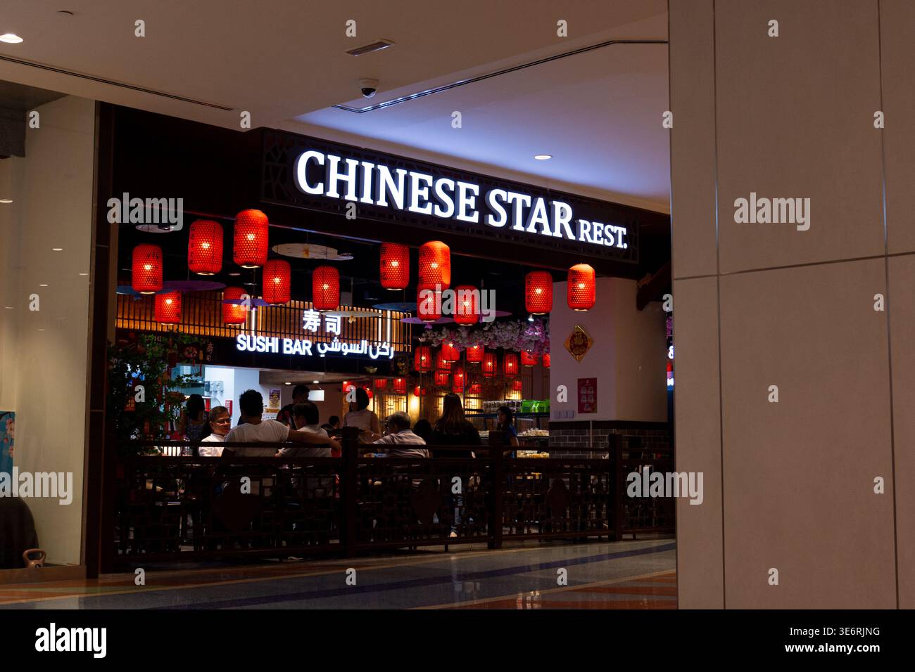 Eingang zum Restaurant Chinese Star im Al Ghurair Centre, mit leuchtenden Schildern, traditionellen roten Papierlaternen und Abendessen für Gäste. Stockfoto