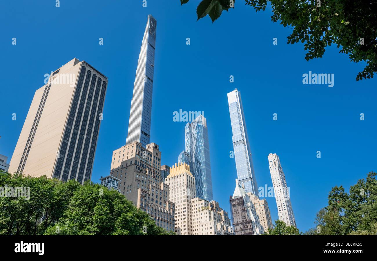 New york, usa, 14. august 2024. Hohe, moderne Wolkenkratzer dominieren die Skyline von manhattan, die hinter grünen Baumkronen des Central Park auf einem klaren klaren klaren Himmel aufragt Stockfoto