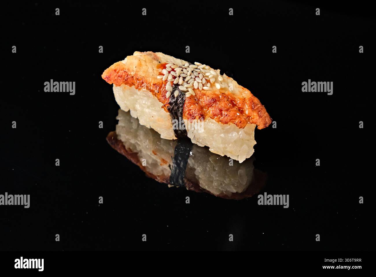 Einzeln gegrilltes Unagi Aal Nigiri Sushi mit Nori, weißem Reis und Sesamsamen isoliert auf schwarzem Hintergrund mit Spiegelreflektion. Teil von Nigiri Sushi Stockfoto
