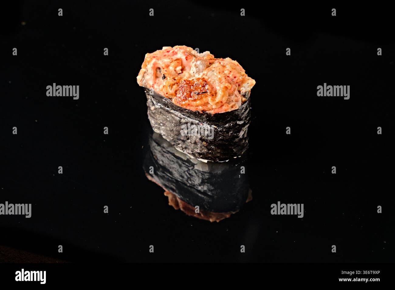 Einfach gebackene scharfe Meeresfrüchte Gunkan Maki Sushi mit Nori Seetang Boot gefüllt mit gewürzten gemischten Meeresfrüchten und scharfer Sauce, isoliert auf schwarzem Hintergrund W Stockfoto