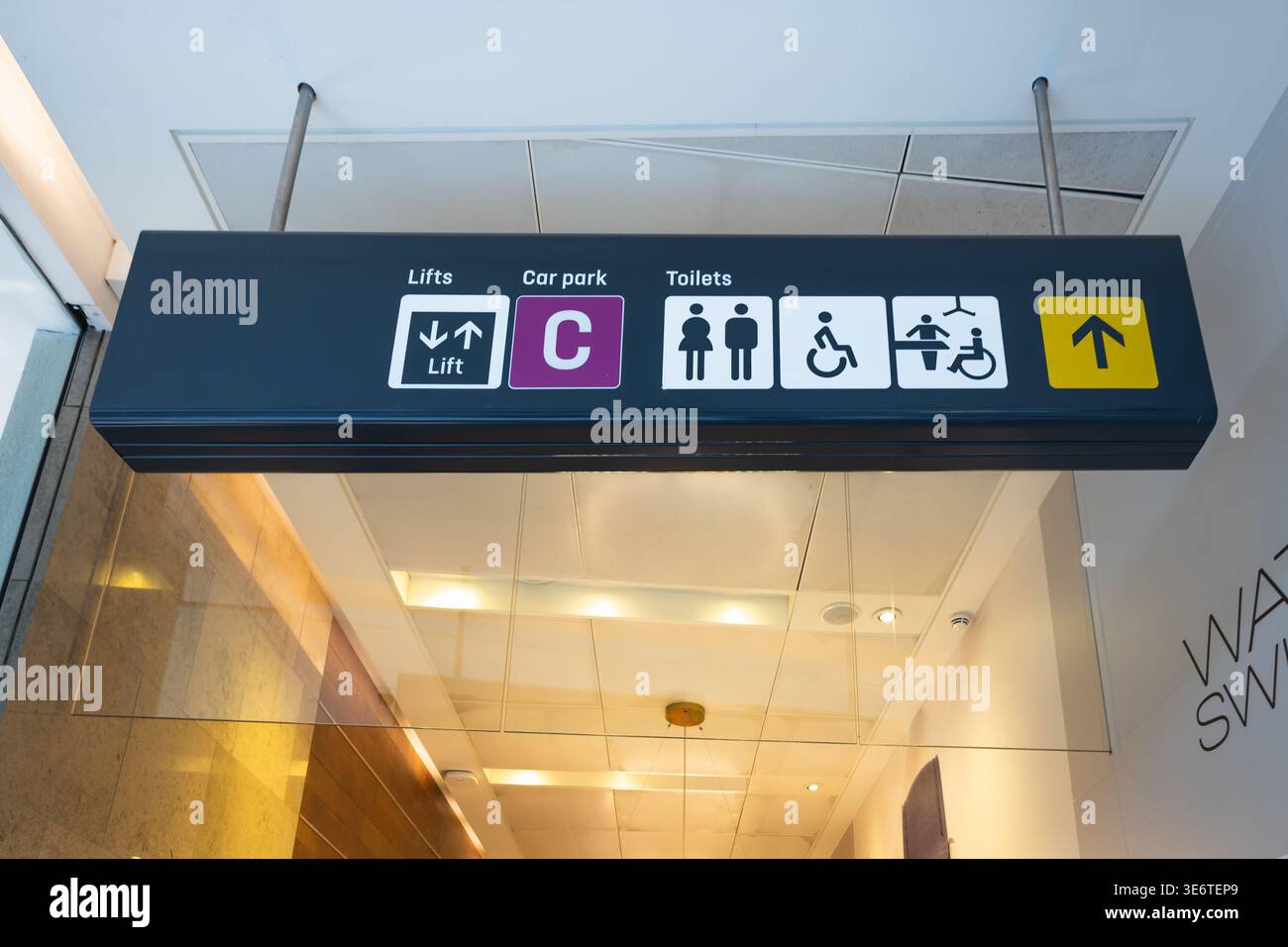 Richtungsschild für Toiletten und Fahrstuhl Stockfoto